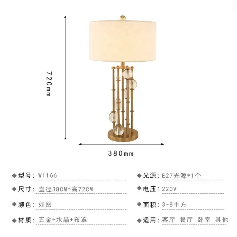 Gold-toned crystal table lamp with cream fabric shade and vertical crystal spheres for bedroom with brass accents