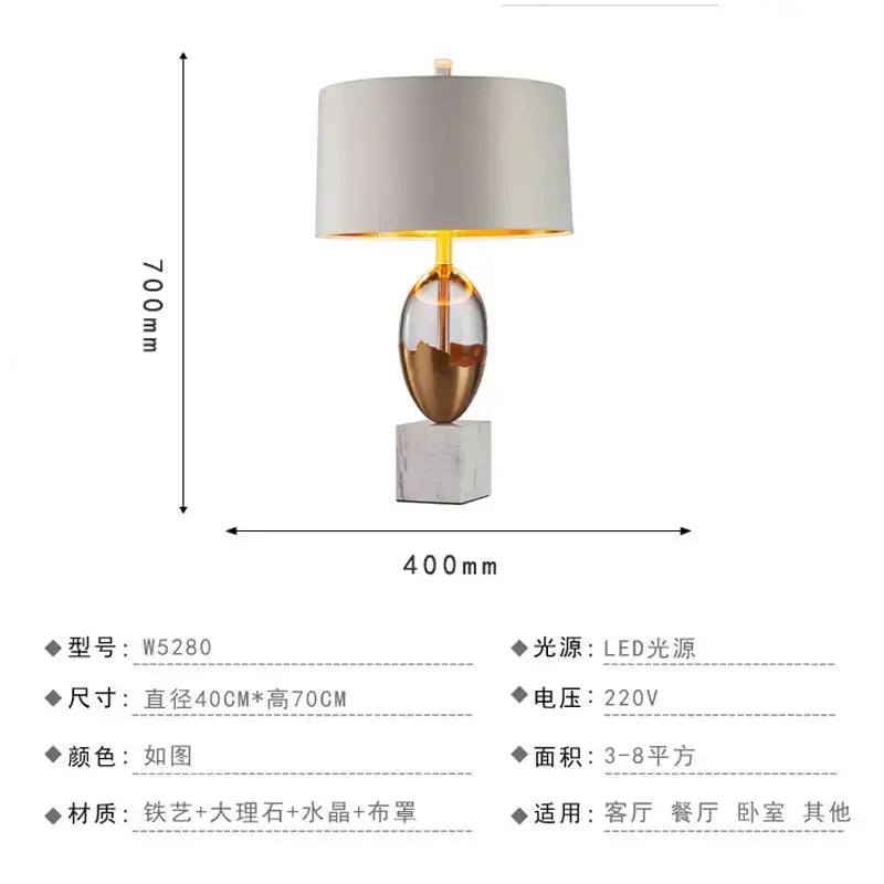 Modern nordic crystal table lamp with an iron and marble oval base, amber-gold glass, and soft gray fabric shade for bedroom