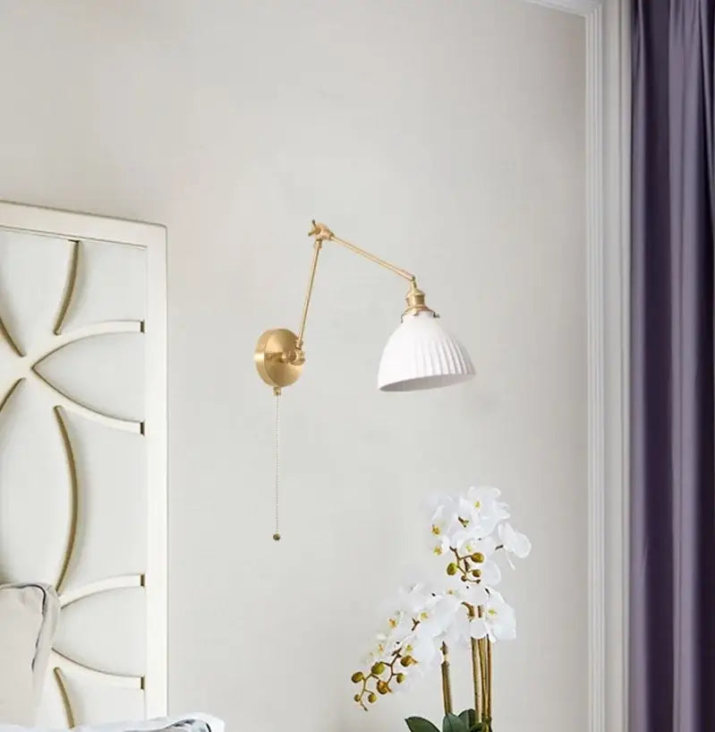 A nordic gold ceramic led wall lamp with adjustable metal arm and white ribbed ceramic shade for bedroom decor