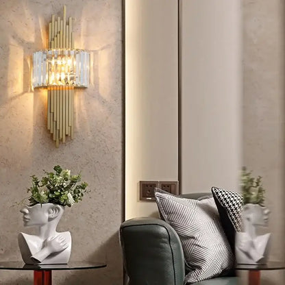 Gold-toned decorbites crystal wall sconce with vertical crystal bars and warm ambient lighting for living room decor