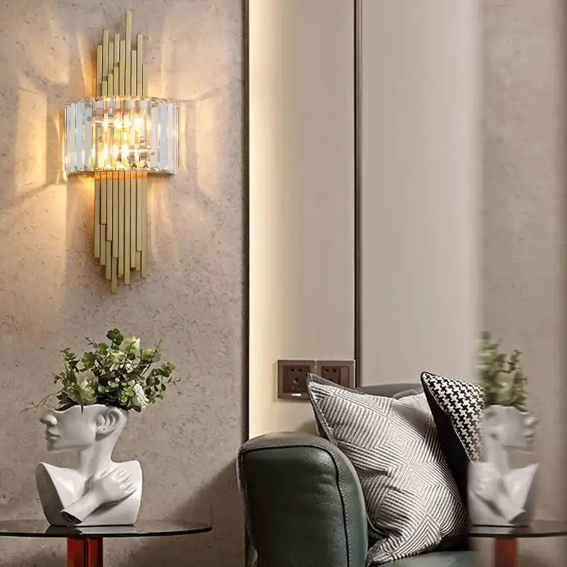 Gold-toned decorbites crystal wall sconce with vertical crystal bars and warm ambient lighting for living room decor