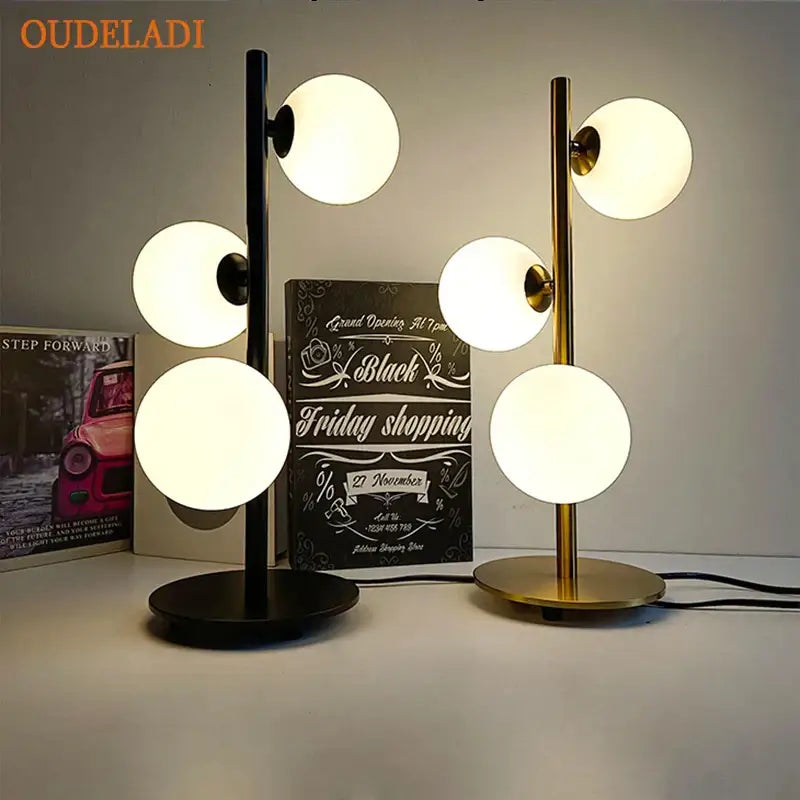 Modern Nordic gold decorbites glass ball led table lamp with sleek black and gold stems and glowing white glass shades for bedroom