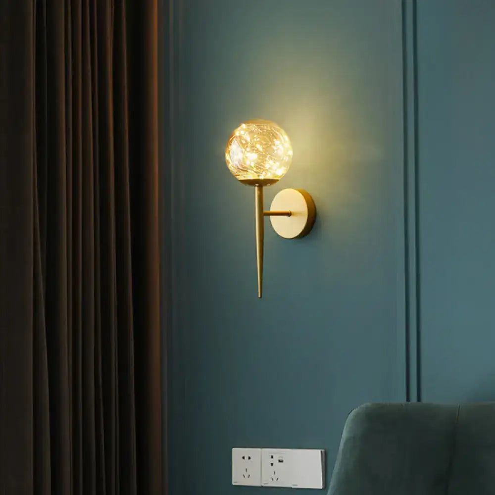 Nordic gold glass globe wall sconce with textured spherical globe and slender metallic stem for bedroom fairy lights