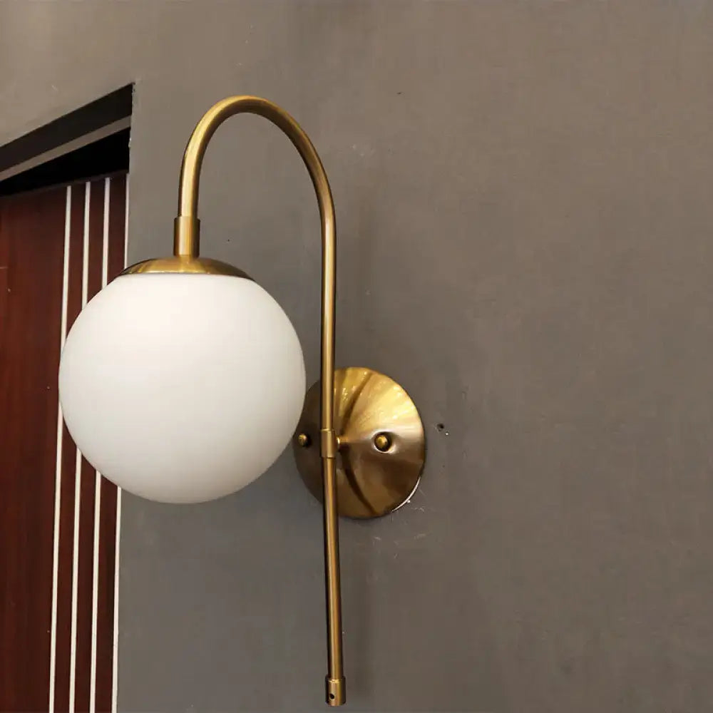 A sleek brass nordic gold wall sconce with milky glass shade suitable for 220v-240v and led incandescent fluorescent bulbs