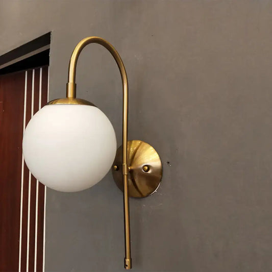 A sleek brass nordic gold wall sconce with milky glass shade suitable for 220v-240v and led incandescent fluorescent bulbs