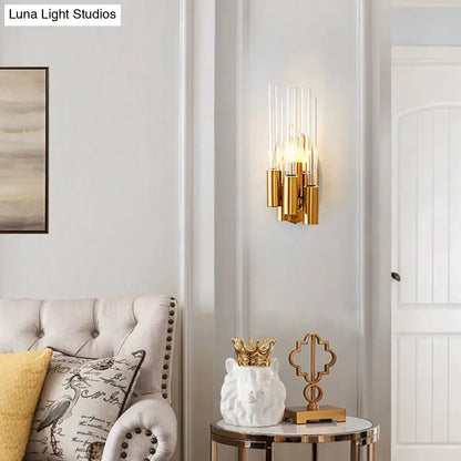 Gold-toned nordic wall lamp with clear glass cylinders and warm glowing bulbs for living room gold tube lighting
