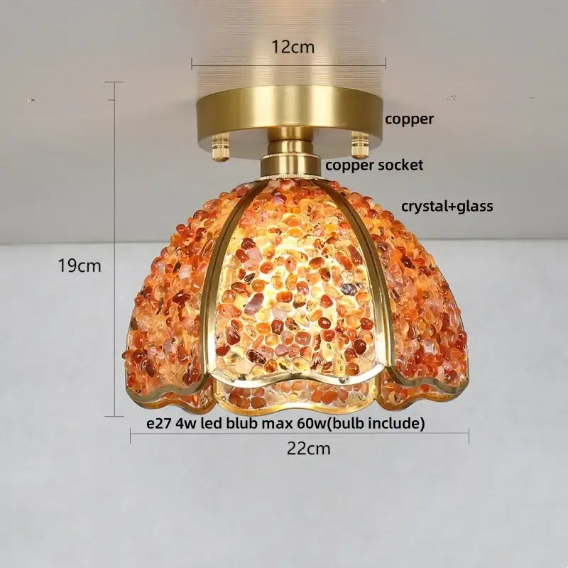 A warm-toned amber pendant ceiling light with copper base and crystal glass shade for bedroom use