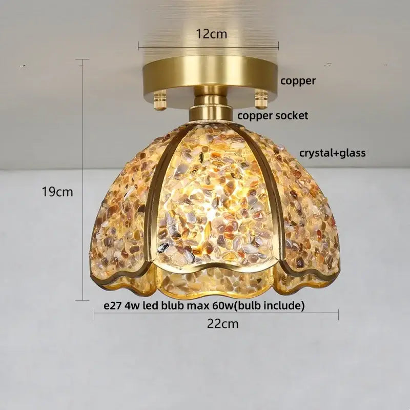 A warm-toned glass crystal ceiling light with scalloped design copper base and amber gold pebbles for bedroom use