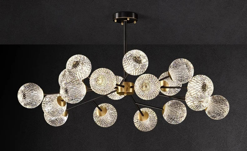 Modern chandelier with clear textured glass spheres and gold-toned metal arms for nordic dining room lighting