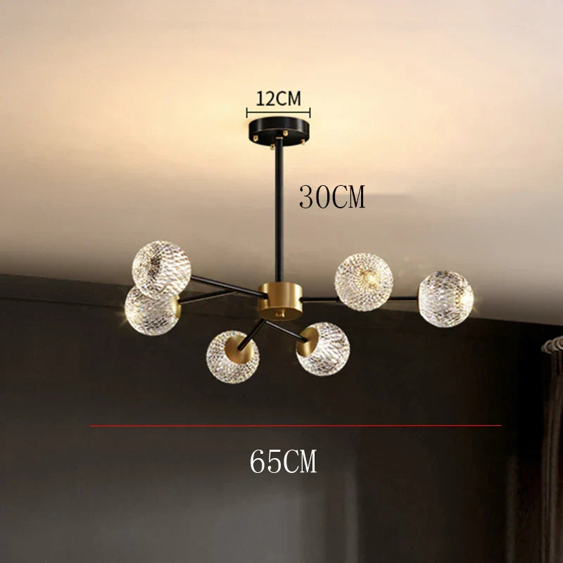 Modern chandelier with six textured glass globe shades and black and brass metal arms for dining room lighting