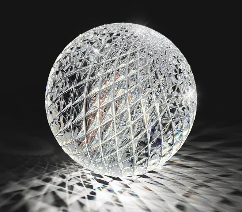 A clear intricately cut crystal sphere with geometric lattice in nordic pendant lamp for dining room lighting
