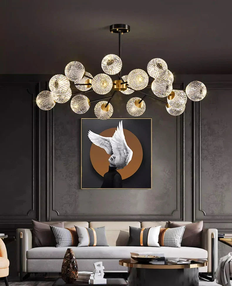 A modern nordic pendant chandelier with clear textured glass orbs and brass fixture for dining and living room lighting