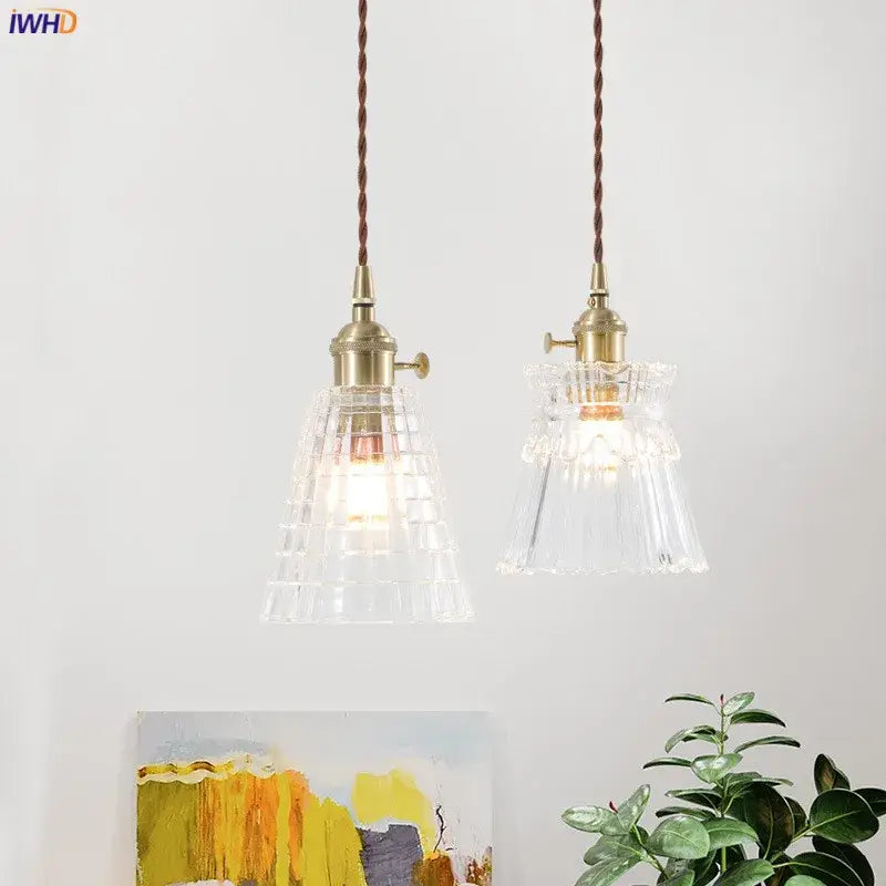 Two nordic japan style pendant lights with brass fixtures and textured clear glass shades for dining room use
