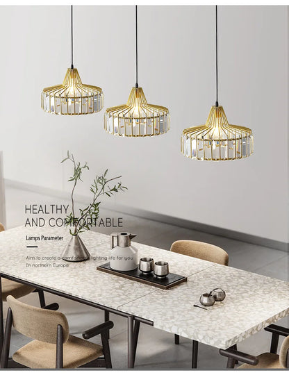 Three elegant gold-toned nordic led crystal pendant lamps with iron accents hang above a modern dining table