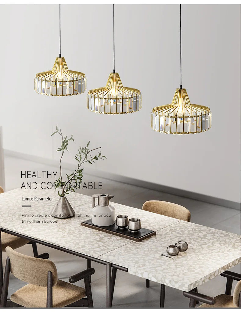 Three elegant gold-toned nordic led crystal pendant lamps with iron accents hang above a modern dining table