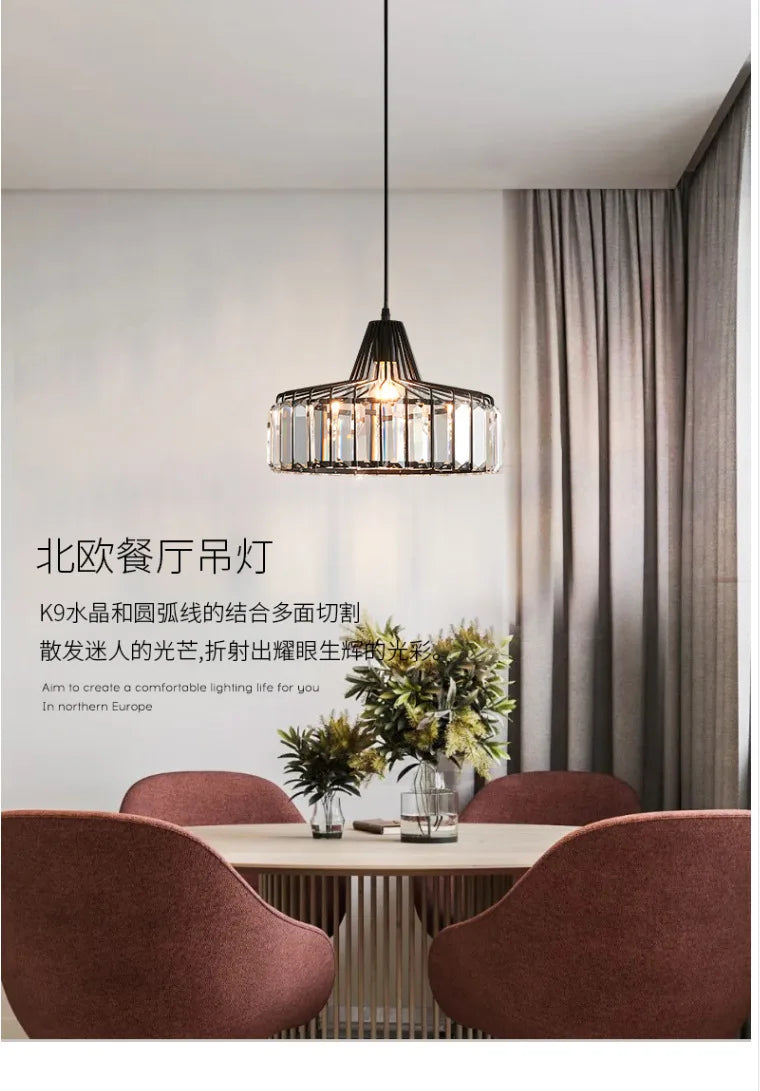 A modern nordic LED crystal pendant lamp with black iron frame and clear K9 crystal accents above dining table