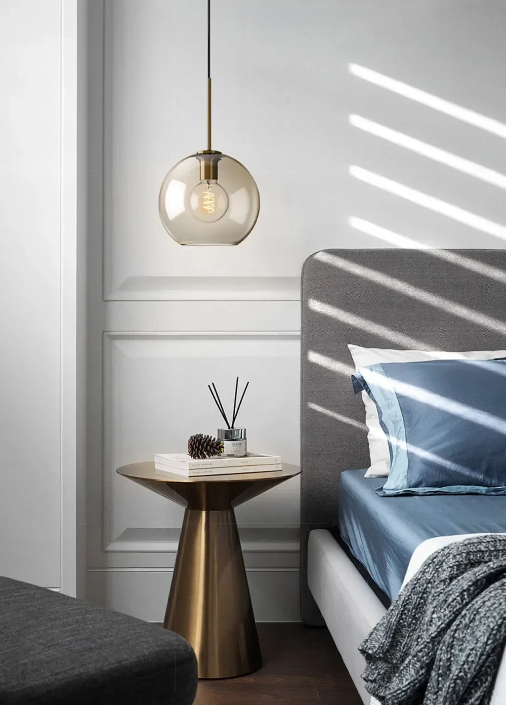 A sleek nordic led glass pendant light with a brass fixture and exposed filament bulb for dining room use