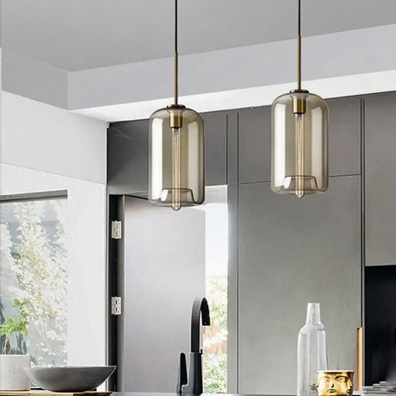 Two modern nordic led glass pendant lights with smoked glass shades and brass accents for dining room use