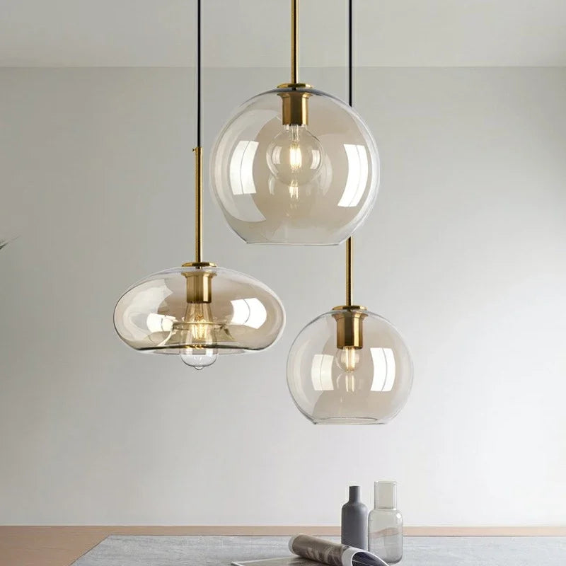 Three nordic led glass pendant lights with clear glass globes and brass accents for dining room decor