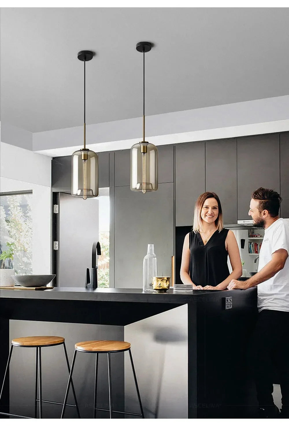 Two sleek nordic led glass pendant lights with smoked glass and brass finish hang in dining room setting