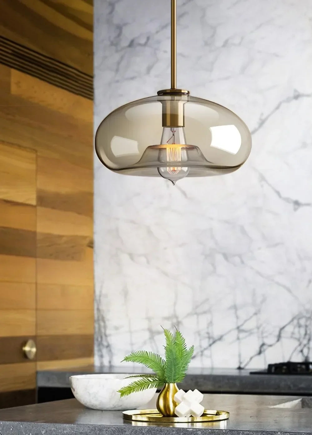 A sleek nordic led glass pendant light with smoked glass and brass finish for dining room and living spaces