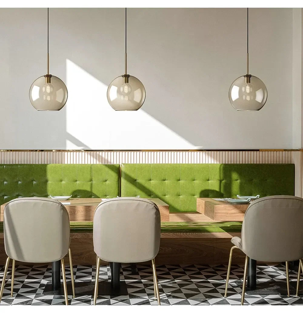 Three spherical smoked glass nordic led pendant lights with brass accents for dining room and living spaces
