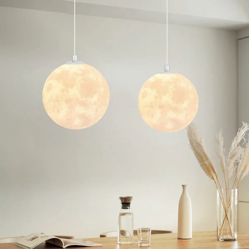 Two warm glowing nordic led moon pendant chandeliers with realistic texture for dining room kitchen lighting