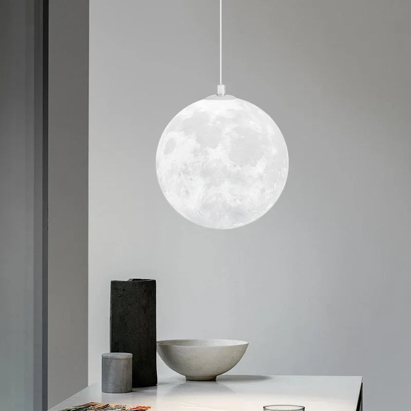 A white spherical nordic led moon pendant light with detailed lunar surface design for dining room kitchen decor