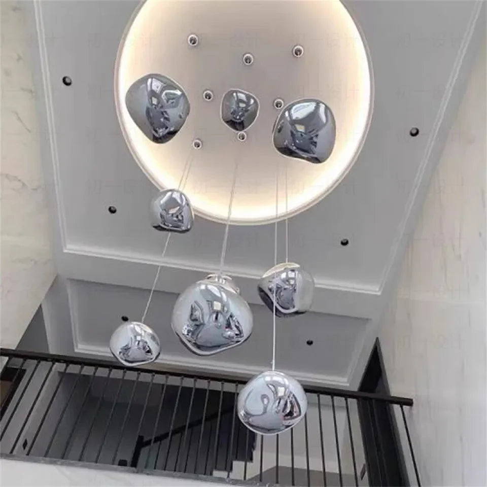 Modern chrome-finished liquid metal pendant chandelier with irregular reflective globes for indoor lighting in living spaces