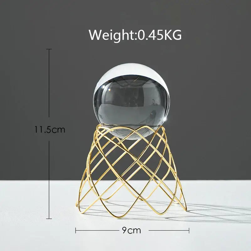 A nordic light luxury crystal ball craft with a sleek two-toned glass sphere on a gold wireframe stand
