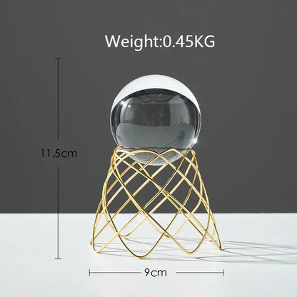 A nordic light luxury crystal ball craft with a sleek two-toned glass sphere on a gold wireframe stand