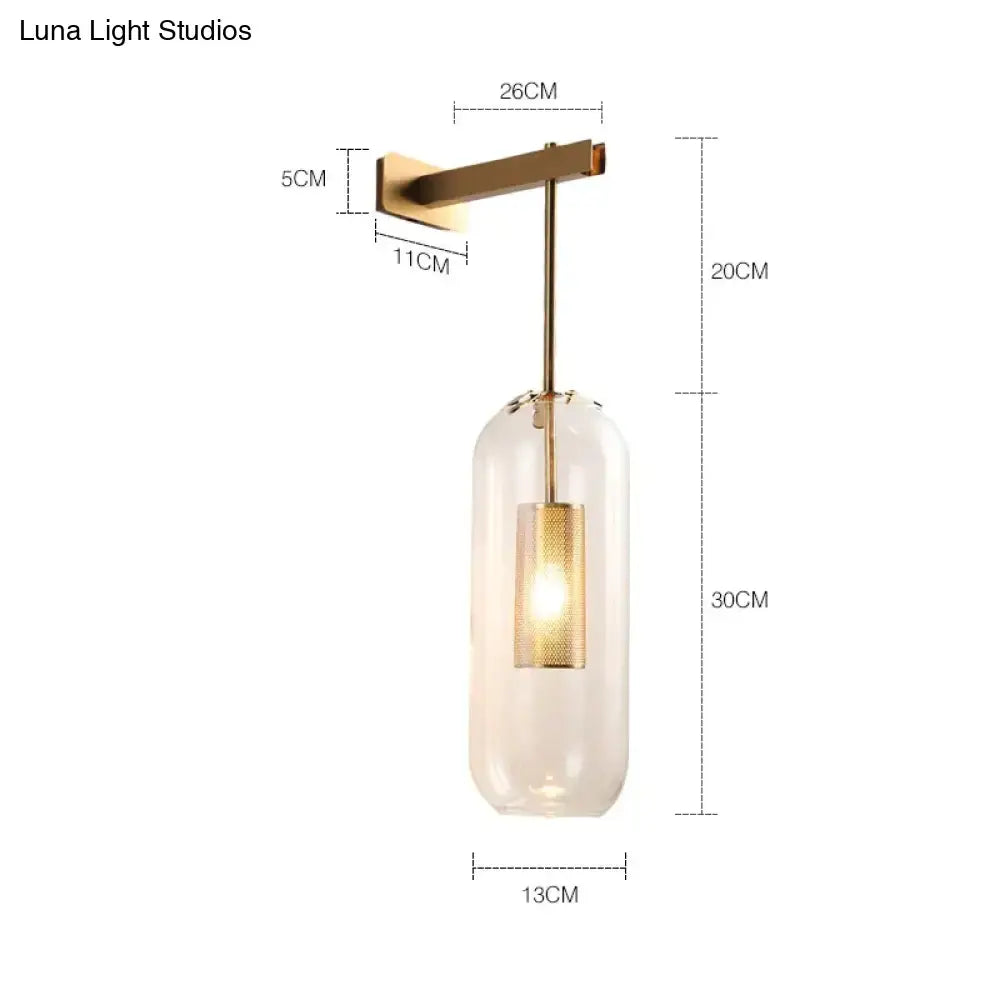 Nordic modern decor brass and glass wall lamp with a clear glass lampshade and illuminated gold mesh bulb for bedroom