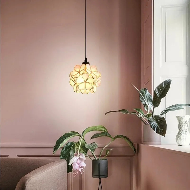 A warm glowing nordic modern pendant lamp with amber acrylic petals in a floral design for bedroom and restaurant