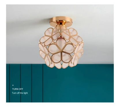 A delicate gold-toned nordic modern pendant lamp with translucent petal acrylic panels for bedroom and restaurant lighting
