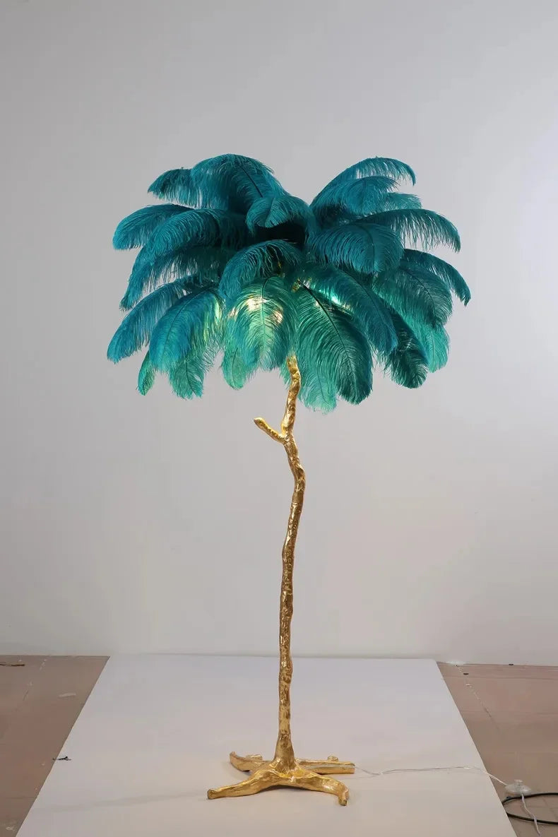 A tall feather floor lamp with a golden tree trunk base and teal ostrich feathers for living room decor