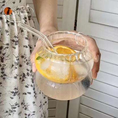 Clear glass pitcher with scalloped rim and handles filled with lemon water featuring glass cocktail cups set decorbites