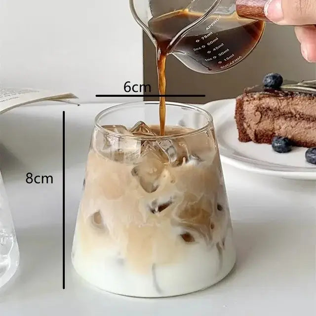 A clear glass cocktail cup filled with iced coffee, 8cm tall, from the nordic pink glass cocktail cups set decorbites
