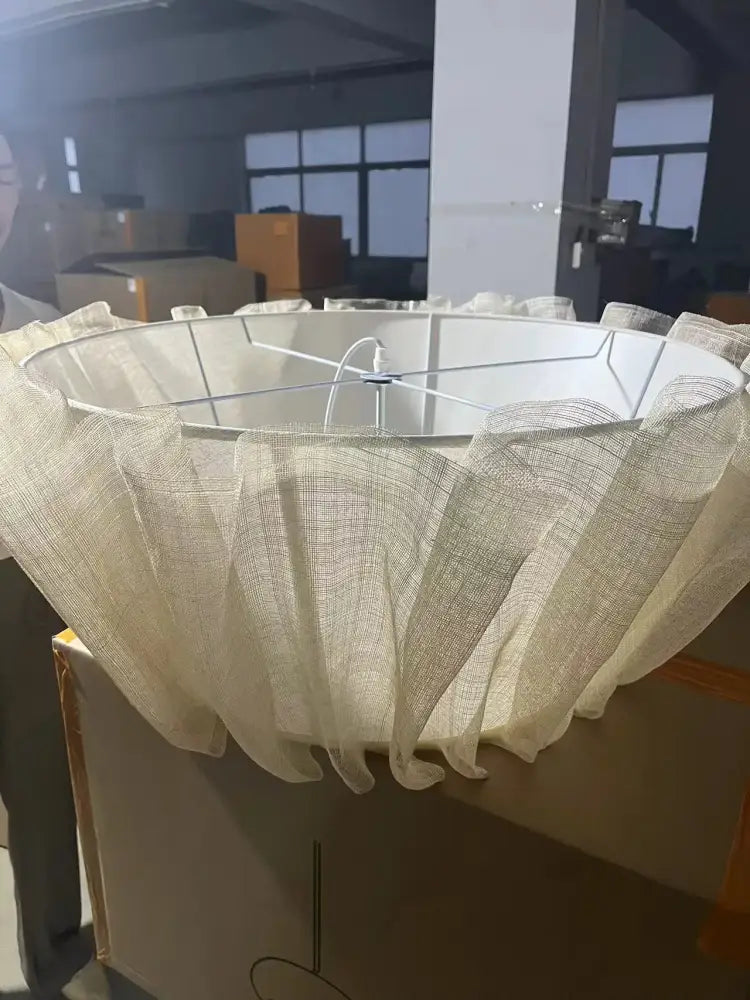 Creamy white fabric pendant light with a sheer mesh fluted lampshade and white metal frame for dining room