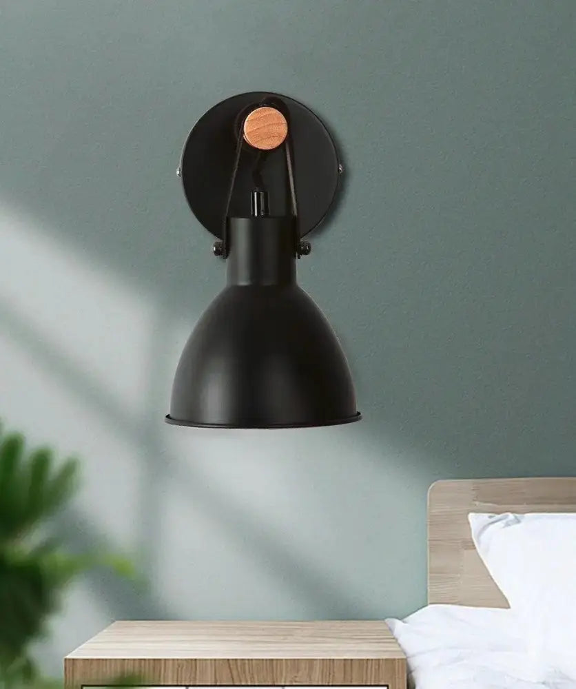 Black metal wall sconce with circular wooden knob and adjustable arm in black finish algunda plug design