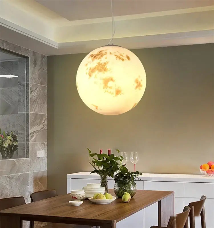 Nordic retro ball moon chandelier pendant light with detailed craters and warm yellowish glow for dining room use