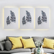 Nordic style banana leaf led wall art with black silhouettes in a three-piece 12 inch fixture with warm backlighting