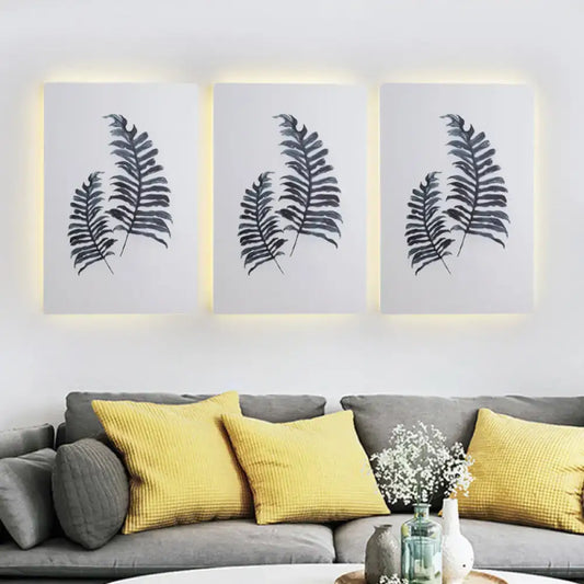 Nordic style banana leaf led wall art with black silhouettes in a three-piece 12 inch fixture with warm backlighting