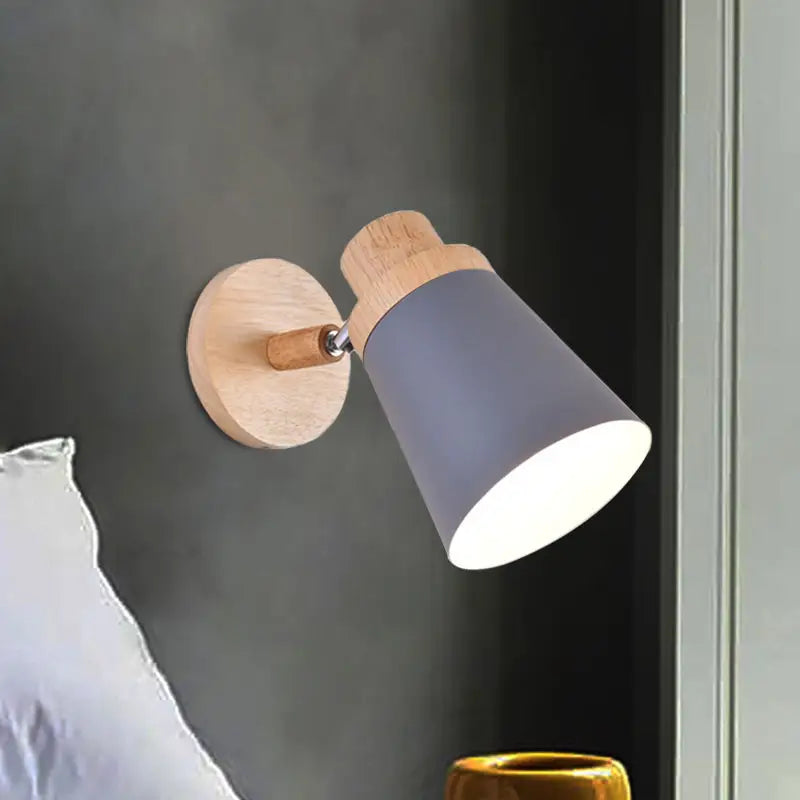 A nordic style wall light with a coolie shade in light gray matte finish and natural wood accents for baby room