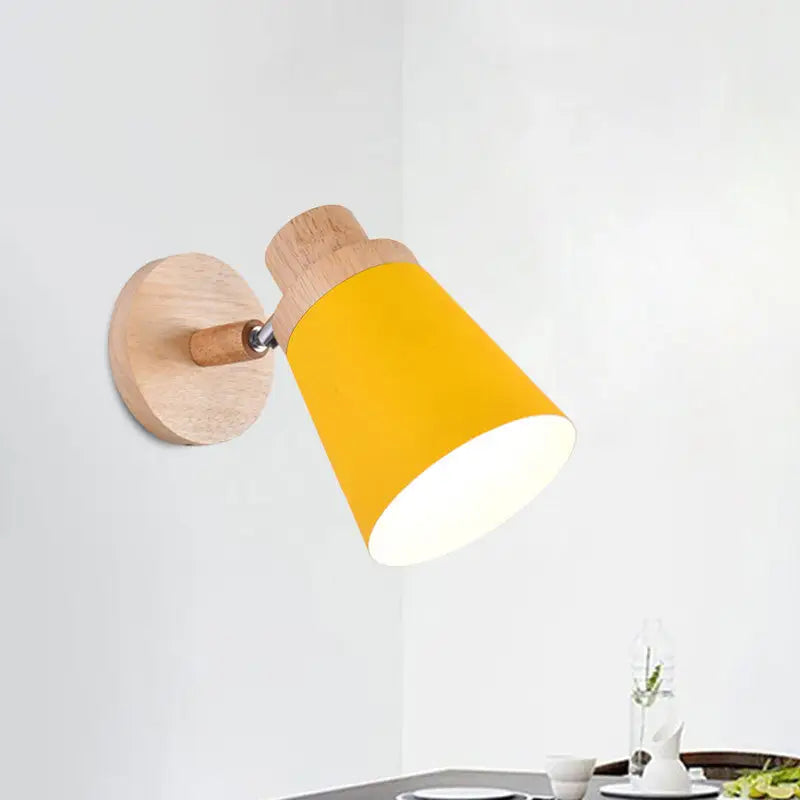 Nordic style wall light with yellow coolie shade mounted on light wood fixture with metallic joint for baby room