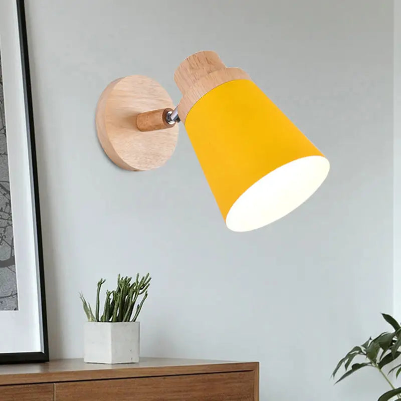 Nordic style wall light with vibrant yellow coolie shade and natural wood finish for baby room lighting