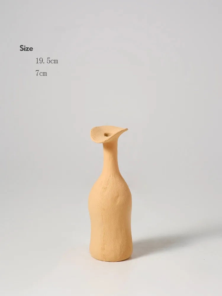 A minimalist beige ceramic vase with a slender neck and flared leaf-like opening for modern nordic home decor