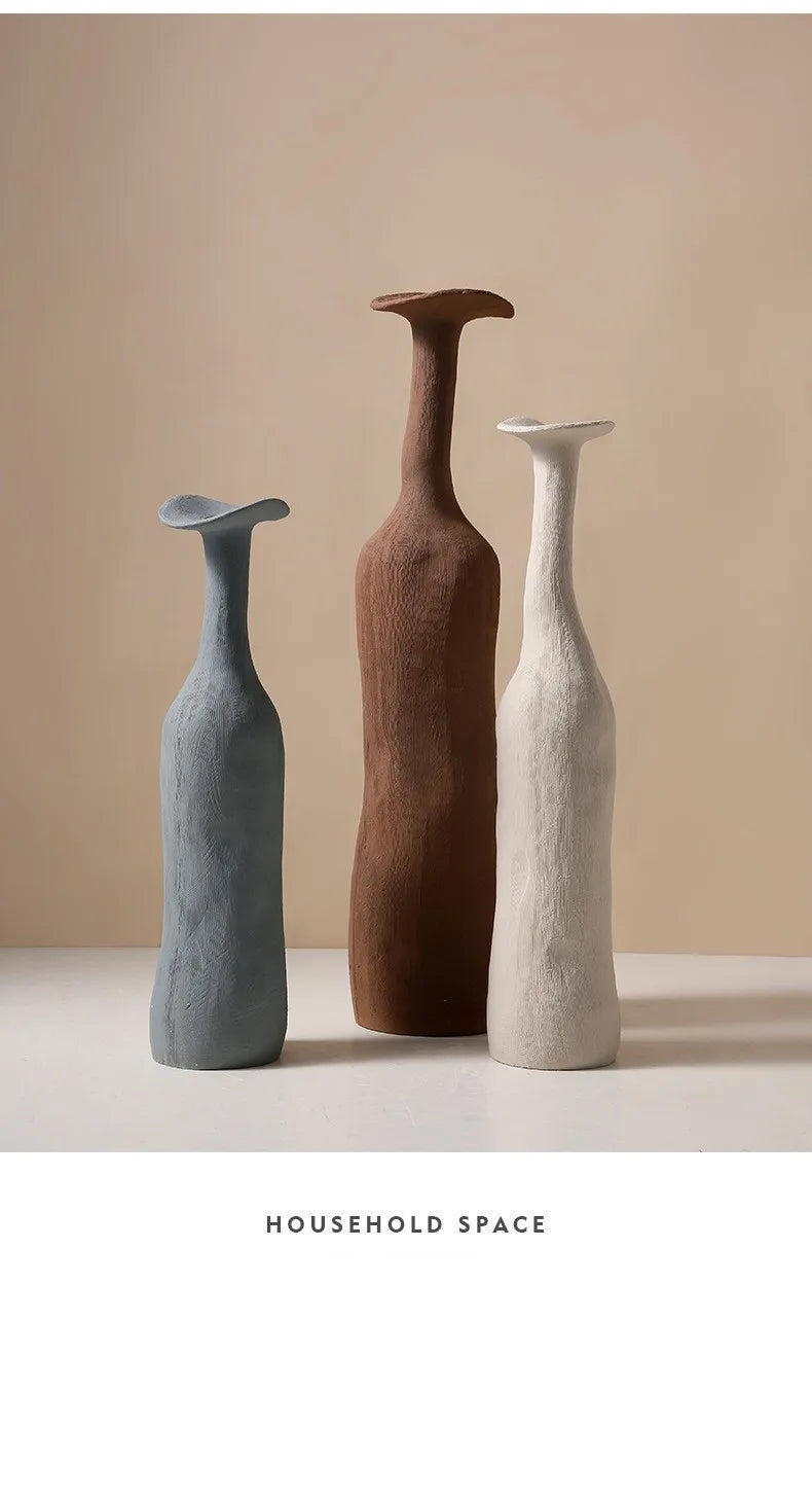 Three sculptural ceramic vases in muted blue earthy brown and off-white with textured surfaces for nordic home decor