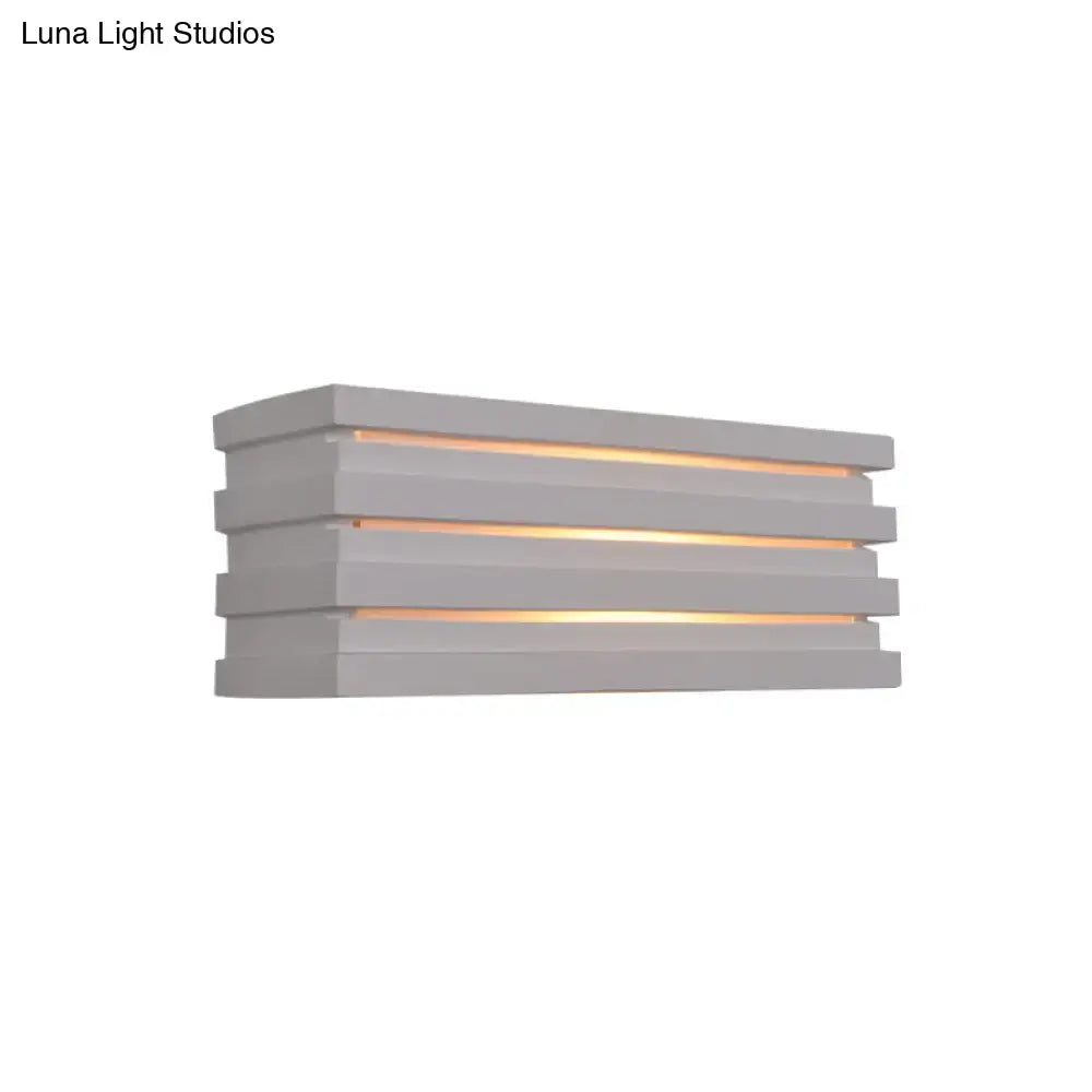 Modern gray bedroom wall sconce with nordic style louvered design and warm ambient glow from horizontal slats