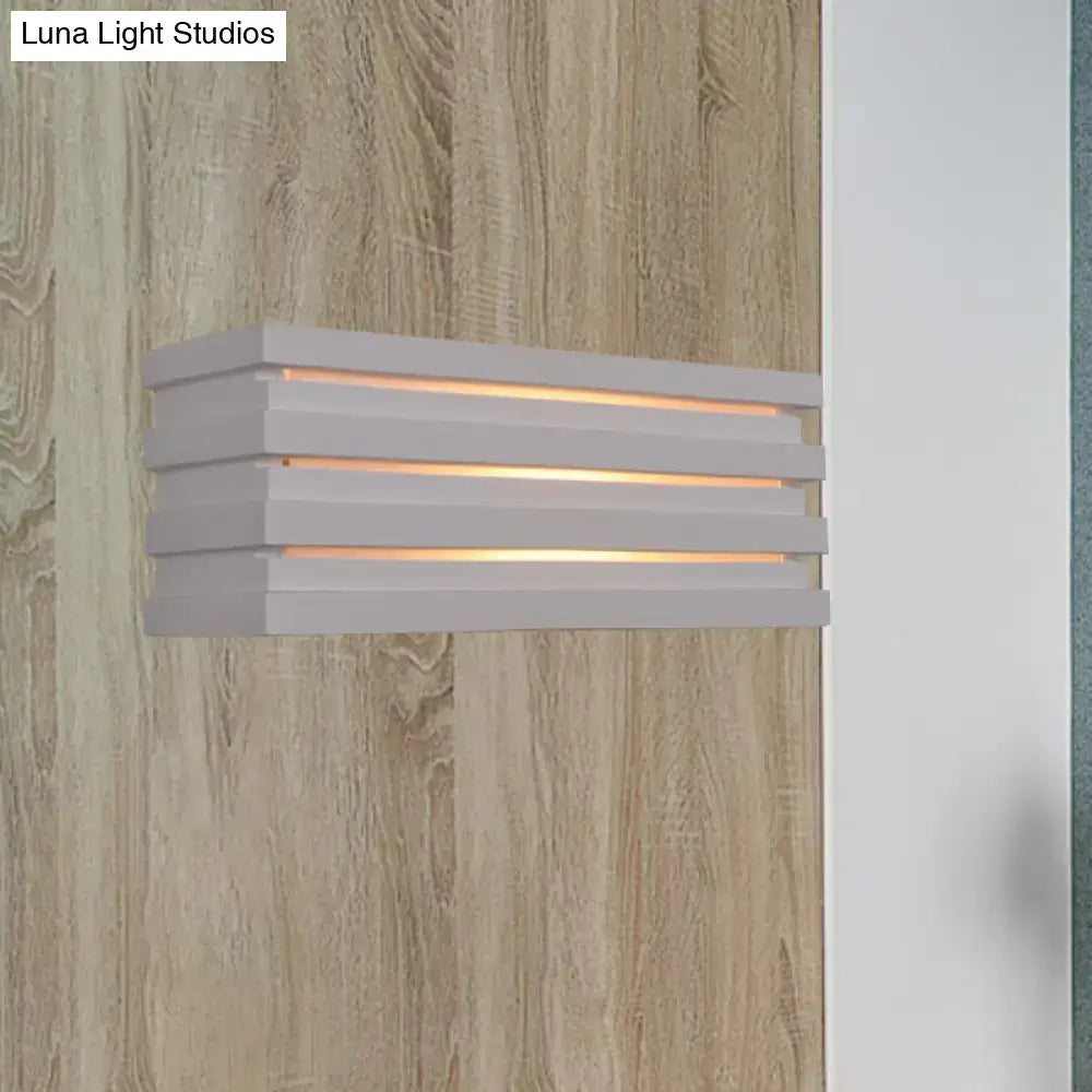Modern white bedroom wall sconce with nordic style louvered design and three horizontal slats emitting warm ambient glow