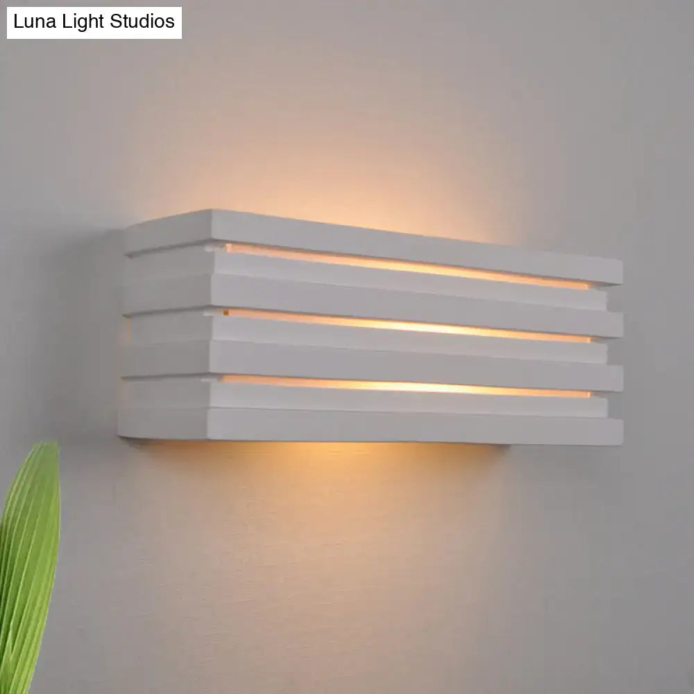 Nordic style white rectangular wall sconce with louvered design emitting warm ambient glow for bedroom lighting